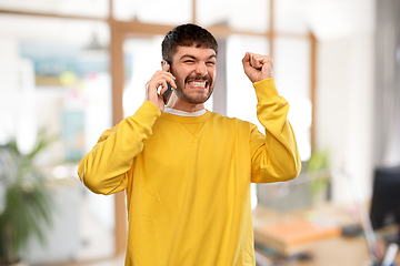 Image showing happy smiling young man calling on smartphone