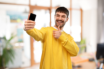 Image showing man takes selfie with phone and shows thumbs up