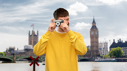 Image showing young man with vintage film camera over london