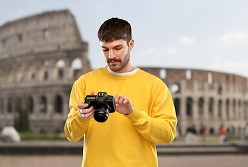 Image showing young man with digital camera over coliseum