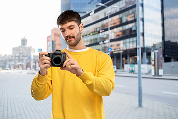 Image showing young man with digital camera over city