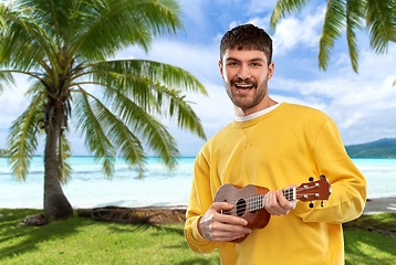 Image showing smiling young man playing ukulele guitar