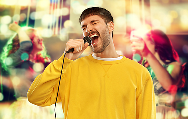 Image showing man with microphone singing at night club