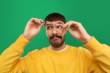 Image showing goofy young man in glasses and yellow sweatshirt