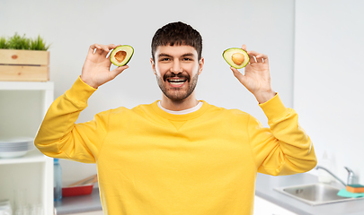 Image showing happy young man in yellow sweatshirt with avocado