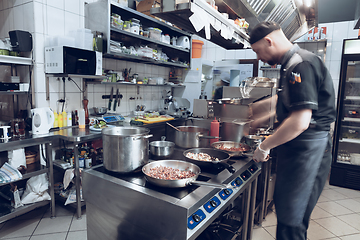 Image showing Behind the scenes of brands. The chef cooking in a professional kitchen of a restaurant meal for client or delivery. Motion.