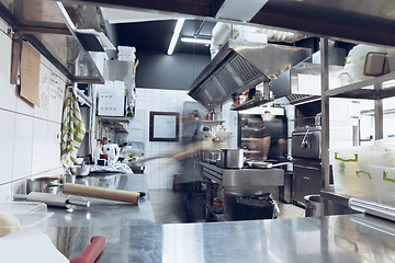 Image showing Behind the scenes of brands. The chef cooking in a professional kitchen of a restaurant meal for client or delivery. Motion.