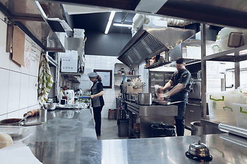 Image showing Behind the scenes of brands. The chef cooking in a professional kitchen of a restaurant meal for client or delivery. Motion.