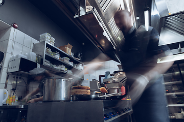 Image showing Behind the scenes of brands. The chef cooking in a professional kitchen of a restaurant meal for client or delivery. Motion.