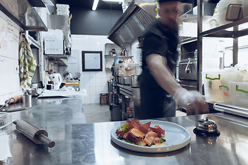 Image showing Behind the scenes of brands. The chef cooking in a professional kitchen of a restaurant meal for client or delivery. Motion.