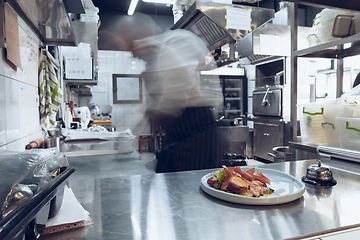 Image showing Behind the scenes of brands. The chef cooking in a professional kitchen of a restaurant meal for client or delivery. Motion.