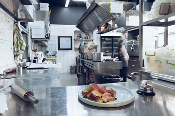 Image showing Behind the scenes of brands. The chef cooking in a professional kitchen of a restaurant meal for client or delivery. Motion.