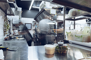 Image showing Behind the scenes of brands. The chef cooking in a professional kitchen of a restaurant meal for client or delivery. Motion.