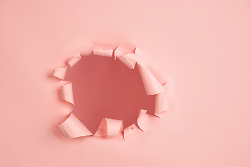 Image showing Torn coral, pink paper hole background, copyspace for ad