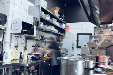 Image showing Behind the scenes of brands. The chef cooking in a professional kitchen of a restaurant meal for client or delivery. Motion.