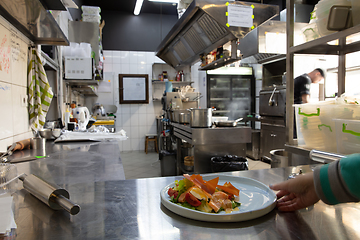 Image showing Behind the scenes of brands. The chef cooking in a professional kitchen of a restaurant meal for client or delivery. Motion.