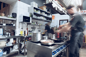 Image showing Behind the scenes of brands. The chef cooking in a professional kitchen of a restaurant meal for client or delivery. Motion.