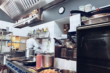 Image showing Behind the scenes of brands. The chef cooking in a professional kitchen of a restaurant meal for client or delivery. Motion.