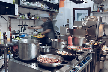 Image showing Behind the scenes of brands. The chef cooking in a professional kitchen of a restaurant meal for client or delivery. Motion.