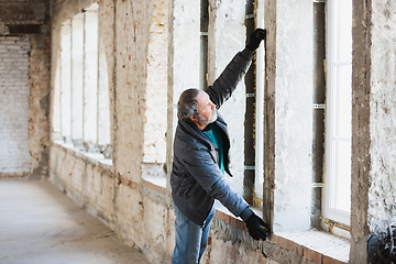 Image showing Close up of hand of repairman, professional builder working indoors, repairing