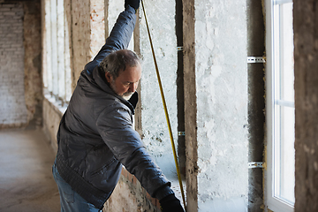 Image showing Close up of hand of repairman, professional builder working indoors, repairing