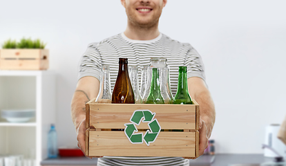 Image showing smiling young man sorting glass waste