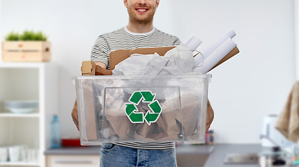 Image showing smiling young man sorting paper waste