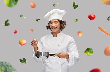 Image showing happy smiling female chef with saucepan over food