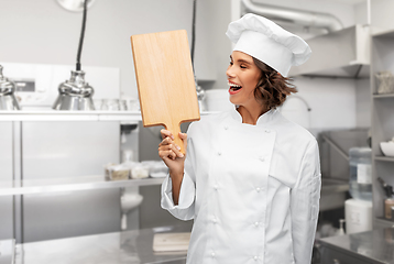 Image showing smiling female chef in toque with cutting board