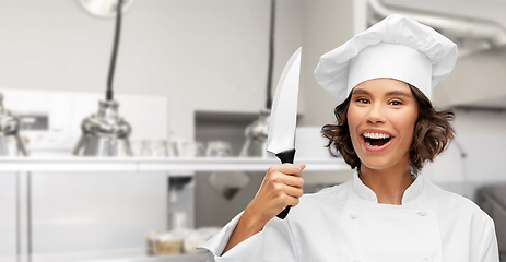Image showing smiling female chef in toque with kitchen knife