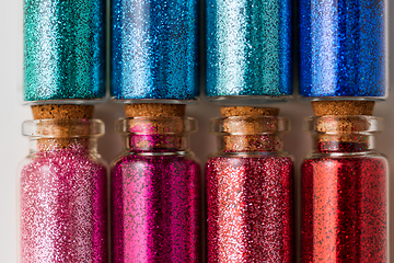 Image showing set of different glitters in small glass bottles