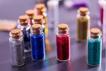 Image showing set of different color glitters in bottles