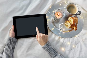 Image showing hands with tablet pc, croissant and coffee in bed