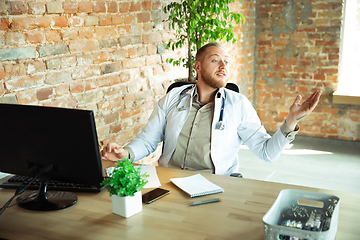 Image showing Caucasian doctor consulting for patient, working in cabinet