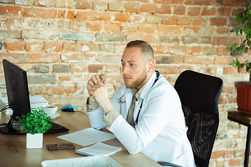 Image showing Caucasian doctor consulting for patient, working in cabinet