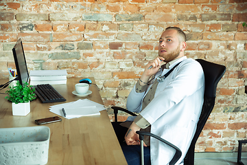 Image showing Caucasian doctor consulting for patient, explaining recipe for drug, working in cabinet