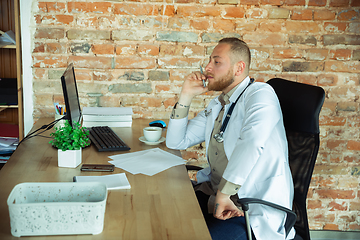 Image showing Caucasian doctor consulting for patient, working in cabinet