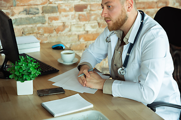 Image showing Caucasian doctor consulting for patient, working in cabinet