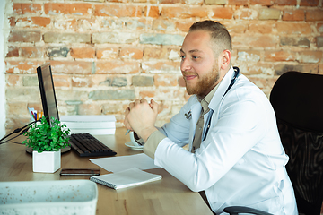 Image showing Caucasian doctor consulting for patient, working in cabinet