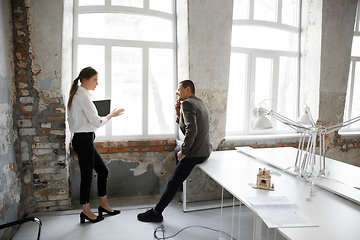 Image showing Female estate agent showing new home to a young man after a discussion on house plans, moving, new home concept