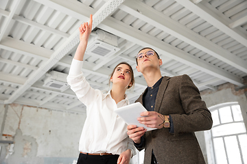 Image showing Female estate agent showing new home to a young man after a discussion on house plans, moving, new home concept