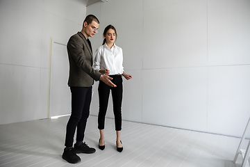 Image showing Female estate agent showing new home to a young man after a discussion on house plans, moving, new home concept