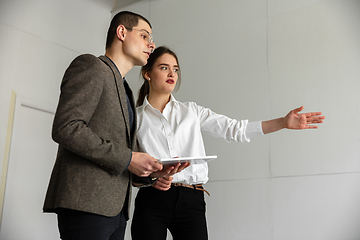 Image showing Female estate agent showing new home to a young man after a discussion on house plans, moving, new home concept