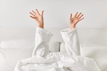 Image showing hands of woman lying in bed and stretching