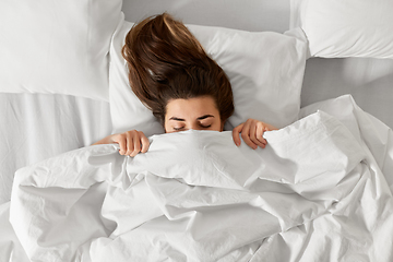 Image showing woman lying in bed under white blanket or duvet