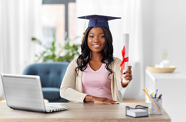 Image showing graduate student with laptop and diploma at home