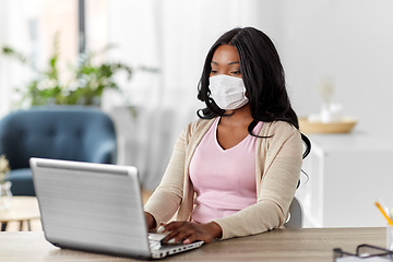 Image showing woman in mask with laptop working at home office