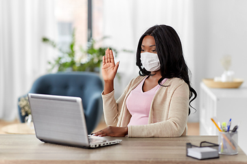 Image showing woman in mask with laptop has video call at home