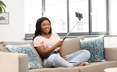 Image showing happy african american woman taking selfie at home