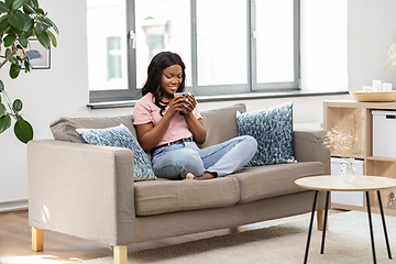 Image showing happy african woman drinking tea or coffee at home